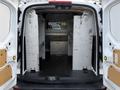 Interior of a 2017 Ford Transit Connect cargo van showing empty space with metal racks and a partition separating the front from the back