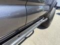 Close-up of the side of a 2010 Toyota Tacoma showing the textured black finish and metal step bar along the vehicle's lower side