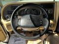 Steering wheel of a 2000 Ford Motorhome with dashboard controls and gauges visible behind it