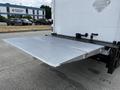 A 2006 Hino 268 with an open aluminum liftgate extended from the rear of the truck