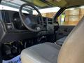 Interior of a 2006 GMC C7C00 featuring a steering wheel dashboard with controls and a cloth-covered driver's seat
