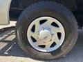 Close-up of a silver alloy wheel from a 2008 Ford E-350 with a rugged tire featuring a bold tread pattern and the Ford logo in the center of the wheel