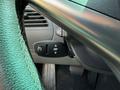 Close-up of a 2004 BMW 6-Series steering wheel showing controls for cruise and various features