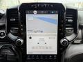 Interior dashboard of a 2024 RAM 3500 featuring a large touchscreen display showing a map and radio information with various control knobs below