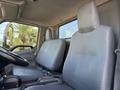 Interior of a 2014 Hino 195 featuring two gray cloth seats with a steering wheel and a simple dashboard