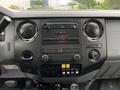 The dashboard of a 2011 Ford F-550 featuring a radio system and various control knobs and buttons