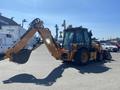 A 2016 Case 580 Super N backhoe loader featuring a front loader bucket and a rear digging arm with extended reach and a distinct orange color
