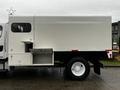 A white 2007 Freightliner M2 106 truck with a boxy cargo area and a side door that is partially open