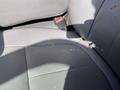 A close-up of the front passenger seat in a 2013 Ford F-250 SD showing dirt and debris on the textured dark gray fabric upholstery