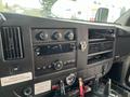 Dashboard of a 2012 Chevrolet Express featuring buttons knobs a radio display and various controls for climate and entertainment systems