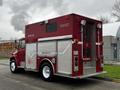 A red 1995 Freightliner FL70 rescue truck with the word RESCUE displayed on the side and various compartments for equipment on the exterior