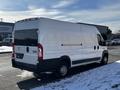 A white 2017 RAM Promaster cargo van parked on the street with a clean rear and side profile showcasing its large cargo capacity and commercial design