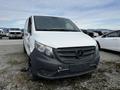 A 2018 Mercedes-Benz Metris van with a white front and gray accents parked among other vehicles