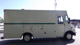 A 2004 Freightliner MT45 box truck with a white exterior and a green stripe running along its side