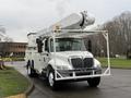 A white 2007 International 4200 truck equipped with a large elevated aerial lift mounted on the roof and a service body in the rear