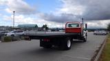 A 2015 International DuraStar 4300 flatbed truck viewed from the rear showcasing its flat cargo area and distinctive cab design