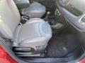 Interior view of a 2015 Fiat 500L showing the front seats and center console with gear shift and cup holders