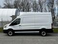 A side view of a white 2020 Ford Transit van with a high roof and cargo space design