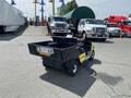 A 1999 Ez-go Industrial utility vehicle with a black and yellow body featuring an open cargo bed and a flat rear section for transporting equipment or materials