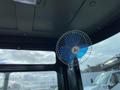 A small blue and white electric fan mounted inside the cabin of a 2024 AGT Industrial QH13R Mini Excavator