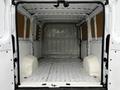 Interior view of a 2018 RAM Promaster cargo van with a spacious and empty rear compartment featuring a bare metal floor and side panels