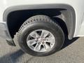 Close-up of a tire mounted on a silver 2018 GMC Sierra 1500 showcasing the wheel design and tread pattern