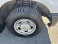 Close-up of a tire mounted on a silver wheel, featuring a rugged tread pattern typical of a heavy-duty truck, specifically from a 2013 Ford F-250 SD