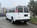 White 2016 GMC Savana van parked with a sleek design and dual rear doors displaying the GMC logo and Savana branding