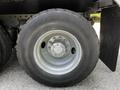 Close-up of a wheel and tire from a 2010 Freightliner M2 106 featuring a silver rim and black rubber tire with the name ST244 printed on the sidewall