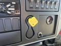 Dashboard of a 2007 International 7300 showing various buttons and controls with a yellow parking brake release switch prominently displayed