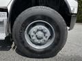 A close-up view of the wheel and tire of a 2010 Freightliner M2 106 with a gray rim and a Michelin tire