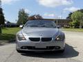 A 2004 BMW 6-Series convertible in silver color facing forward with its headlights on and grille prominently displayed