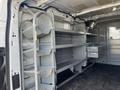 A 2016 Ford Transit van interior featuring metal shelving units and storage compartments mounted along the walls