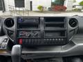 The image shows the dashboard of a 2014 Hino 195 featuring a radio stereo system multiple control knobs and a series of buttons for various functions