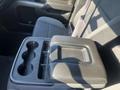 A center console in a 2015 Chevrolet Silverado 1500 featuring cup holders and a removable storage compartment