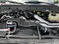 The engine compartment of a 2016 Ford F-550 showing various components like an air intake, hoses, and fluid reservoirs