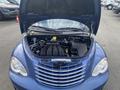 A blue 2007 Chrysler PT Cruiser with its hood open showcasing the engine compartment and various components including hoses and a battery