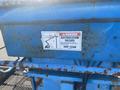 A 1997 Genie S-65 4X4 with a warning sign indicating an electrocution hazard advising to keep clear