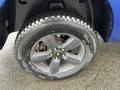 A close-up of a black alloy wheel with five spokes mounted on a 2019 RAM 1500 Classic tire showcasing a rugged tread design