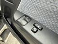 A close-up view of the driver's side door panel of a 2009 Toyota Hiace featuring power window controls and a central locking button