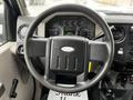 A close-up of the steering wheel and dashboard of a 2008 Ford F-450 SD showing speedometer and various controls