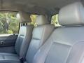 Two grey leather seats in the front of a 2012 Ford F-450 SD with a third headrest visible in the background