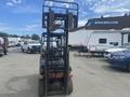 A 2010 Toyota 7FGGU25 forklift with a vertical mast and two forks in the upright position