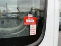A red certificate of approval sticker on the window of a 2007 GMC F7500 vehicle with months labeled from August to November and a number in the corner