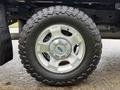 Close-up of a silver alloy wheel with a rugged tire on a 2016 Ford F-350 SD showcasing the intricate design of the wheel and the tread of the tire