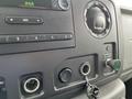 The dashboard controls of a 2009 Ford Econoline featuring audio knobs buttons and input jacks
