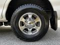 Close-up of a silver alloy wheel and tire from a 2003 Mitsubishi Delica showcasing the detailed tread and rim design