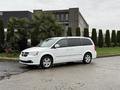 A white 2017 Dodge Grand Caravan is parked at an angle with its side view visible showing its sleek design and five-spoke wheels