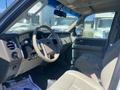 Interior view of a 2013 Ford Expedition featuring a beige steering wheel and seats with controls on the dashboard and floor mats visible