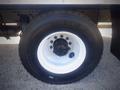 Close-up of a wheel and tire of a 2016 Freightliner M2 106 Medium Duty truck showing the black tire treads and white rim